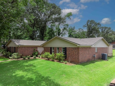 Ranch-style home featuring brick siding, central AC, a front lawn, and a shingled roof