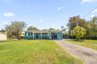 View of front of house with a front lawn, a carpor