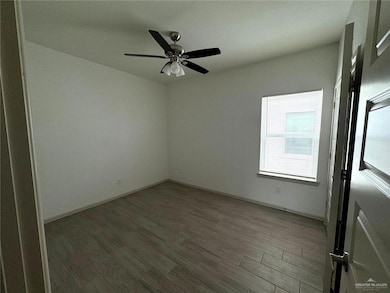 Empty room with wood finished floors and ceiling fan