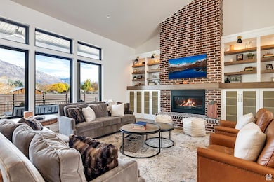 Living room featuring a brick fireplace and high vaulted ceiling