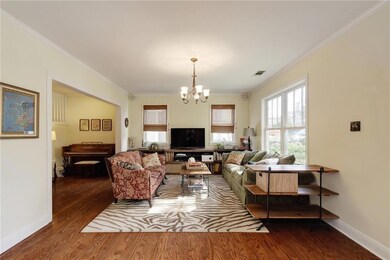 Living room featuring crown molding, wood finished floors, and a chandelier