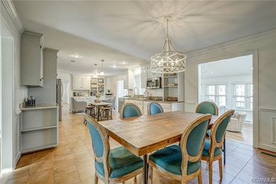 Tiled dining area featuring a chandelier, sink, an