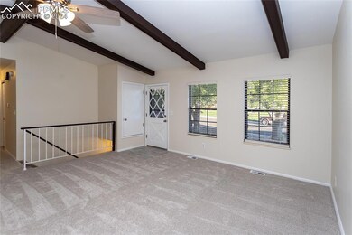 Unfurnished room featuring ceiling fan, light colored carpet, and beam ceiling