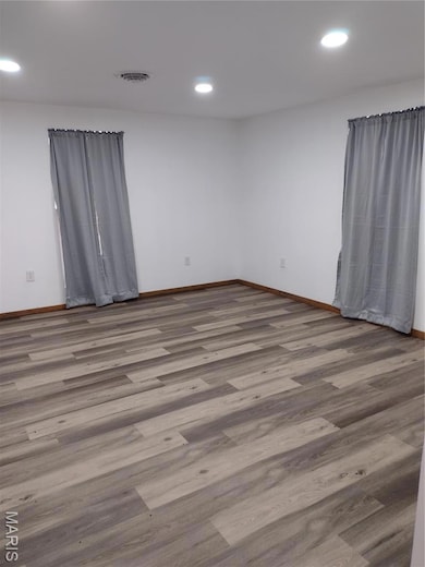 Spare room featuring wood finished floors and recessed lighting