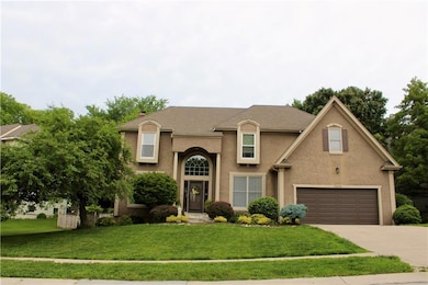 View of front of home with driveway, a front lawn, a garage, and stucco siding