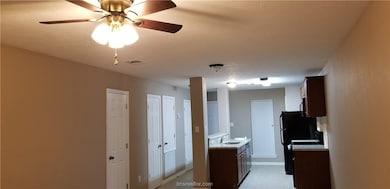 Kitchen featuring light countertops, dark brown cabinets, and black stove