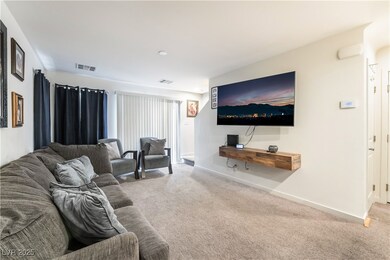 Carpeted living area with visible vents and basebo