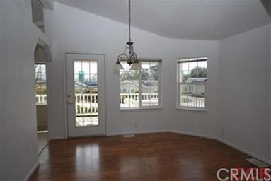 Dining room features a vaulted ceiling, pendant li