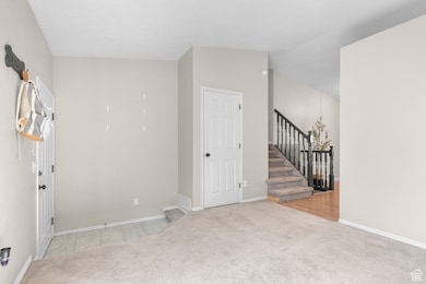 Spare room featuring light carpet and stairs