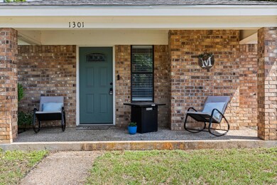 Property entrance with brick siding, covered porc