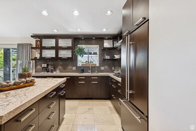 Kitchen with dark brown cabinets, recessed lighting, open shelves, appliances with stainless steel finishes, and decorative backsplash