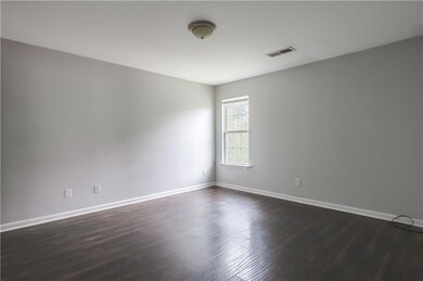 Spare room with dark wood-style floors and baseboards