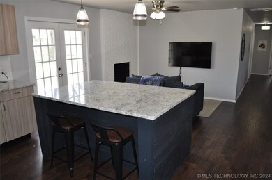 The granite island has chairs for 2 on both sides
