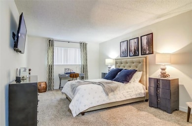 Bedroom with light carpet and a textured ceiling