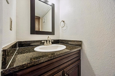 Bathroom with vanity and a textured wall