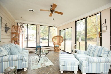 Sunroom featuring ceiling fan, a baseboard heating