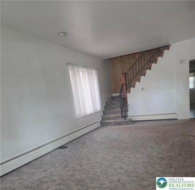 Enter the spacious living room.  Probably hardwood under carpet.