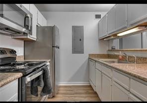 Kitchen featuring white cabinets, electric panel,