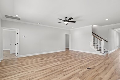 Unfurnished living room with ceiling fan, crown mo