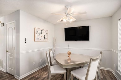 Dining room featuring dark wood-style flooring, a textured ceiling, and ceiling fan