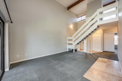 Light, bright living area offers two story ceilings, beam accents and a great flow into the kitchen and dining space.