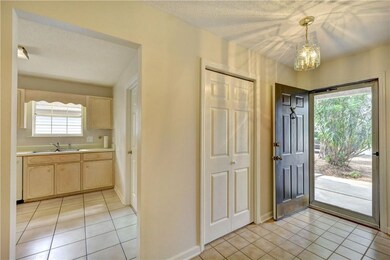 Foyer to kitchen with tiled floors, coat closet &