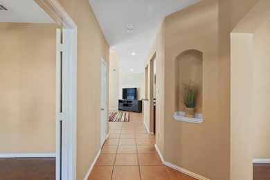 Hallway featuring light tile patterned flooring, b