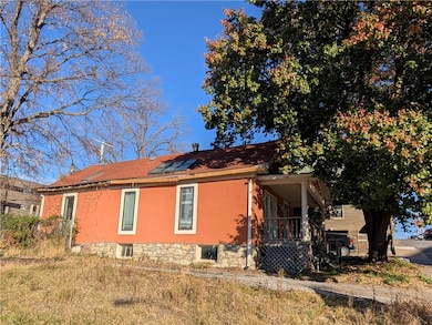 View of side of home with roof mounted solar panels and a porch