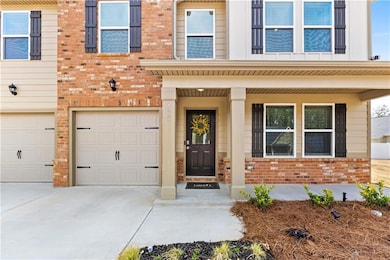 Doorway to property featuring a garage, brick sidi