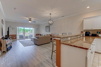 Kitchen featuring a peninsula, a kitchen breakfast bar, white cabinetry, ceiling fan, and light stone counters