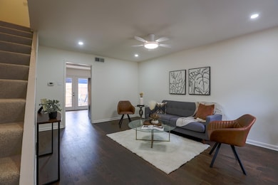 Living room featuring stairway, dark wood-style f