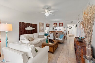 Living room with ceiling fan and light tile patter
