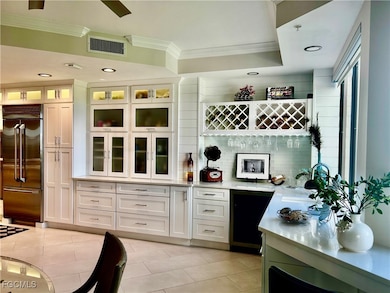 Indoor dry bar featuring white cabinetry, recessed lighting, tasteful backsplash, built in fridge, and light tile patterned floors