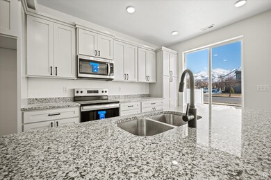 Kitchen featuring visible vents, a sink, light stone counters, recessed lighting, and appliances with stainless steel finishes