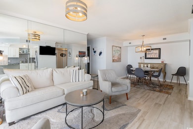 Living area featuring visible vents, crown molding, a chandelier, and ceramic tile floors