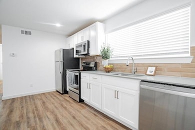 Kitchen with sink, tasteful backsplash, light hard