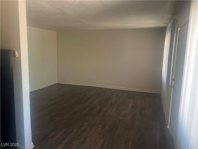 Empty room with baseboards, dark wood-style floori
