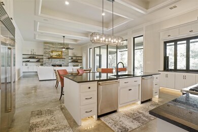 Kitchen featuring a fireplace, a tray ceiling, sta
