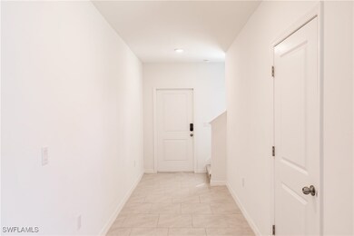 Hall featuring light tile patterned flooring