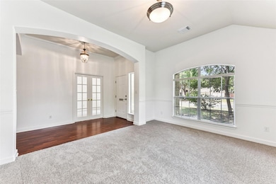 Spare room featuring dark colored carpet, arched 