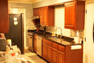 Kitchen with crown molding, a sink, stainless stee