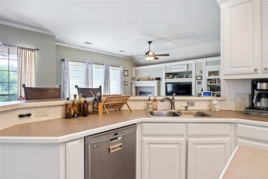 Kitchen with sink, dishwasher, white cabinetry, an