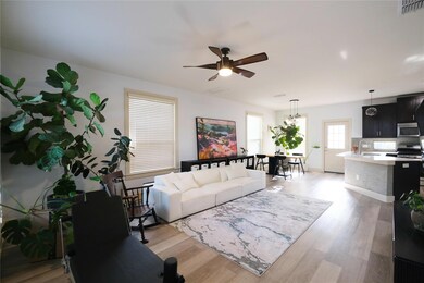 Living area featuring a ceiling fan and light woo