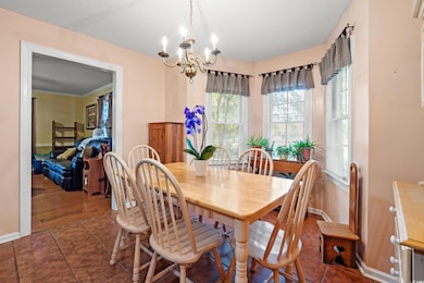 Dining area with a chandelier, baseboards, and dark tile patterned floors