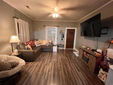 Living room with ornamental molding, ceiling fan, and dark hardwood / wood-style flooring