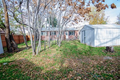 Back of property featuring a shed, a fenced backyard, and brick siding