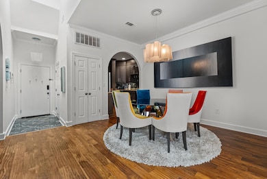 Dining room with dark wood-type flooring and ornamental molding