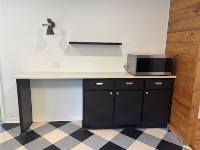 Kitchen with stainless steel microwave, dark cabi