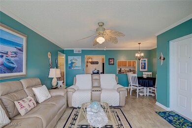Living area with a chandelier, ceiling fan, crown