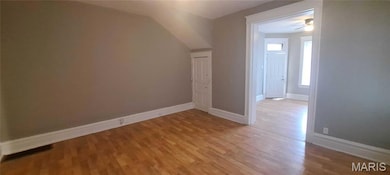 Additional living space featuring light wood finished floors, vaulted ceiling, and ceiling fan